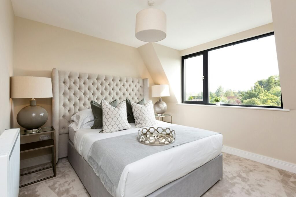 Bright bedroom with a large window and white bedding