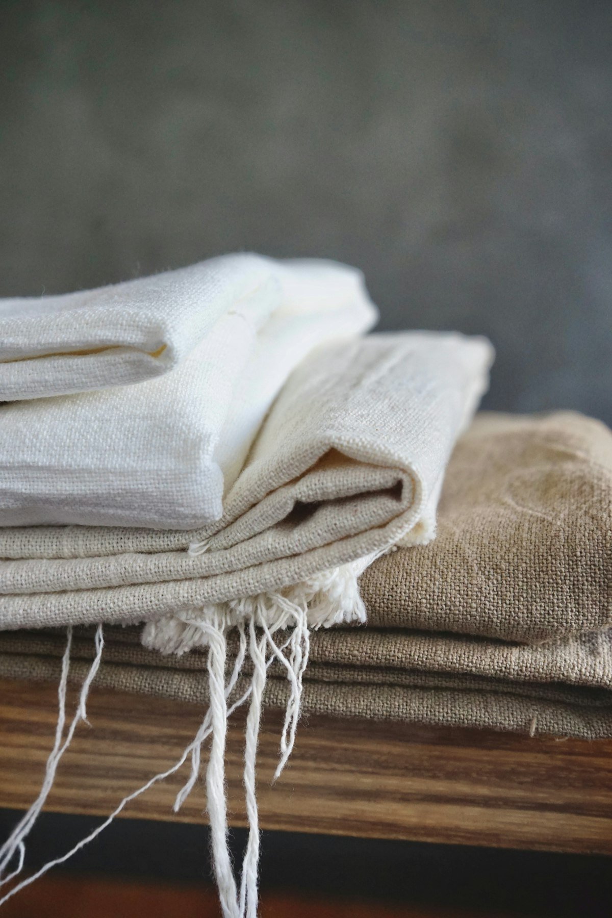 Folded white cotton bed linens stacked for a new home
