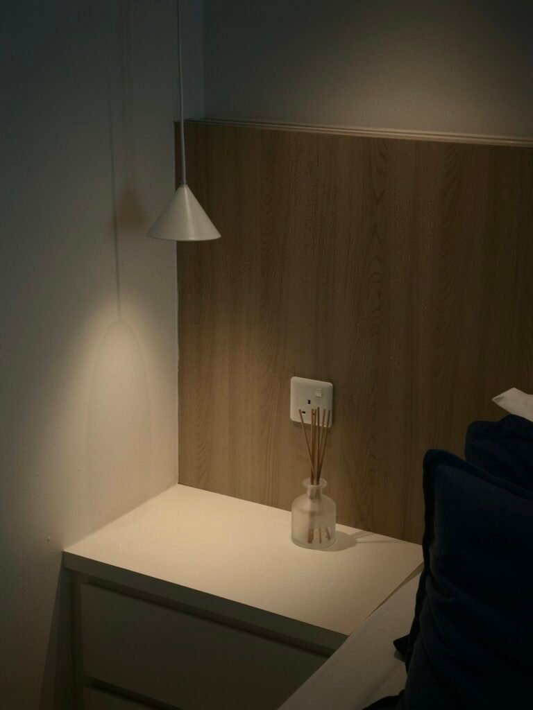 Reed diffuser on a white nightstand in a bedroom